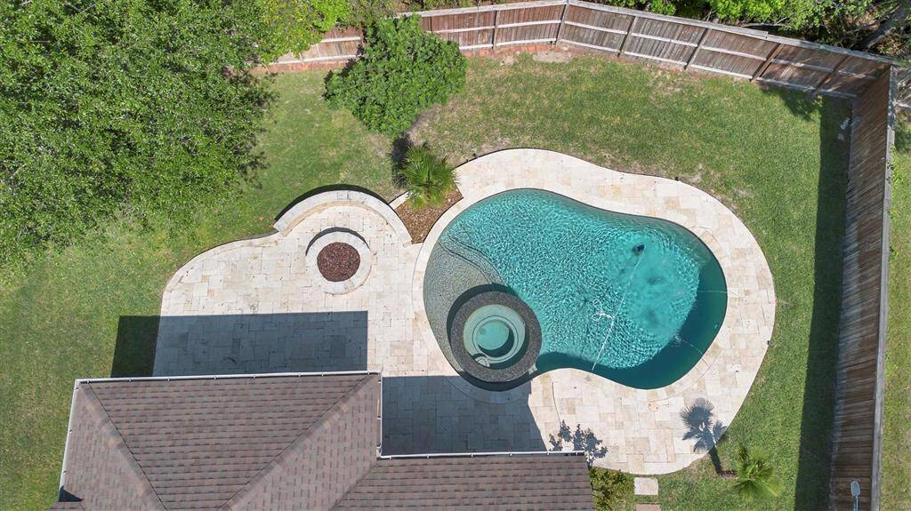 From above, you can see just how perfectly this backyard is designed for both play and relaxation featuring a sparkling pool with spa, cozy firepit, and plenty of green space to roam. It’s the ultimate setting for soaking up the sun or enjoying cool evenings under the stars.
