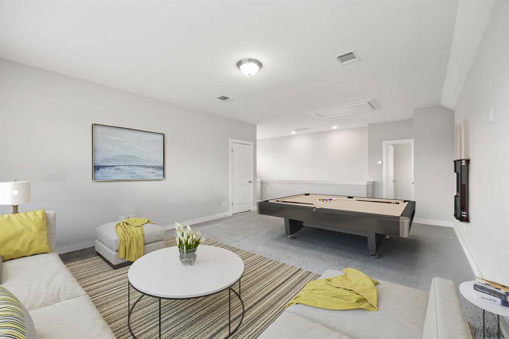 This spacious, well-lit game room features enough space for a pool table, cozy seating area and a multitude of different uses.