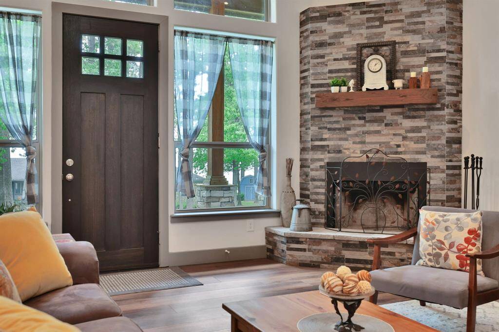 This is straight out of your dream home Pinterest board—cozy, inviting, and full of charm! The rich wood tones, stone fireplace, and soft natural light make this space feel like a warm hug.