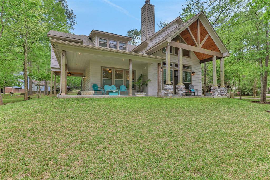 Relax and entertain on the expansive covered porch of this beautiful home, nestled amongst mature trees.