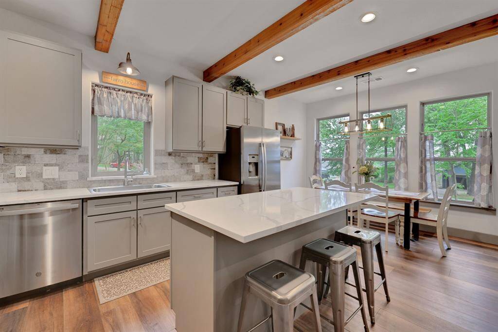 The kitchen features Quartz countertops, an open dining area, and stainless steel appliances.
