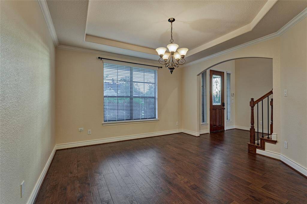 The spacious dining room features elegant arches, crown molding and a tray ceiling.
