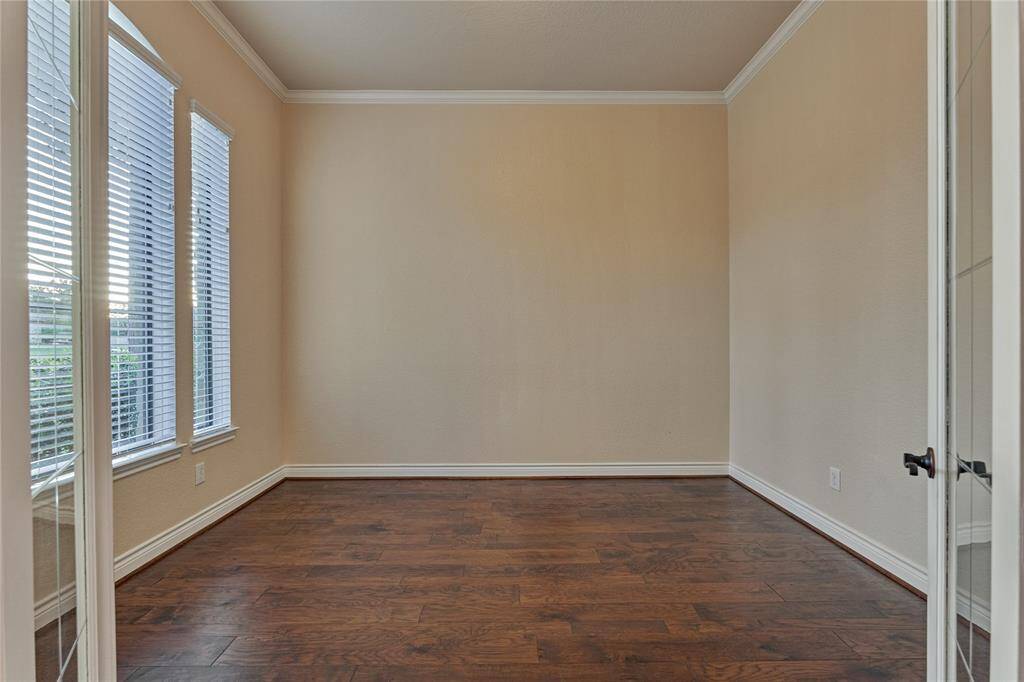 The home office is to the left of the foyer and features French doors and crown molding.
