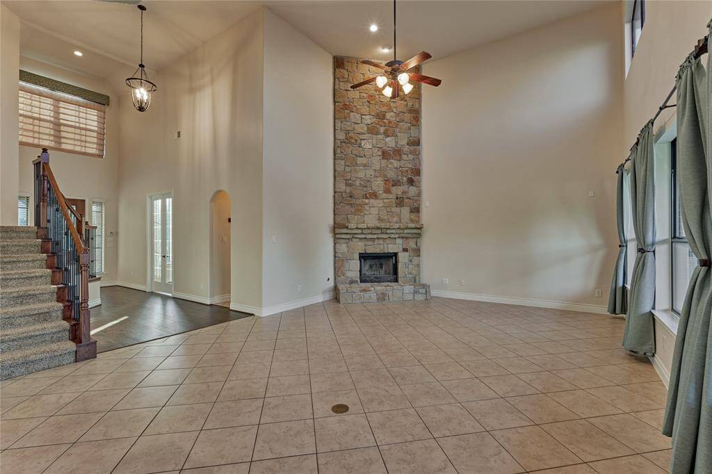 The 2-story family room offers soaring ceilings, serene views of the backyard through a wall-of-windows and a floor-to-ceiling stone fireplace that is just incredible.