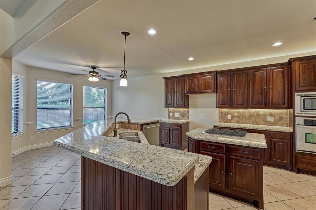 This culinary oasis boasts of rich wood cabinetry, gleaming granite countertops and stainless steel appliances.