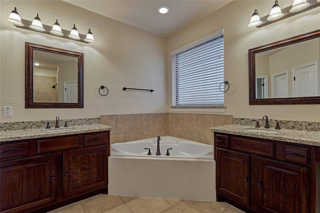 Rich wood cabinetry and tasteful finishes complete this spa-like retreat.