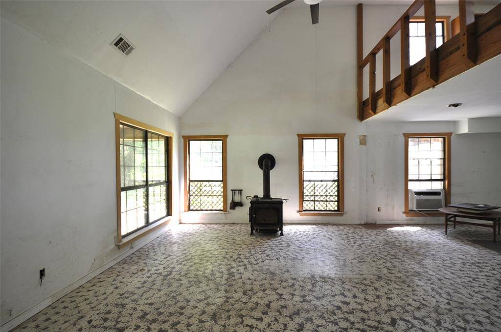 Living room has wood burning stove.  Lots of windows lets in lots of natural light.