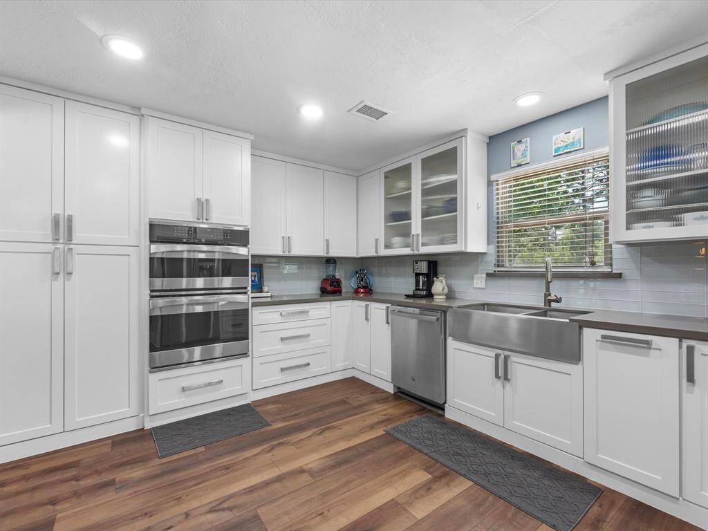Gorgeous farm house sink and stainless appliances plus glass front cabinets offer a modern touch to this lovely kitchen