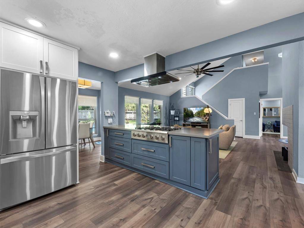 The oversized island shows off the gas cook top and range hood with extra space to pull up stools. This is a wonderful entertaining home!