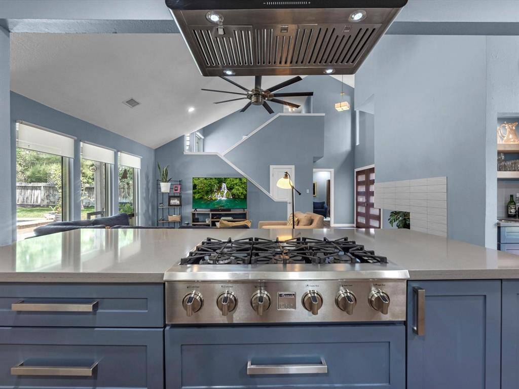A closer view of the cook top and island overlooking into the family room in this open plan