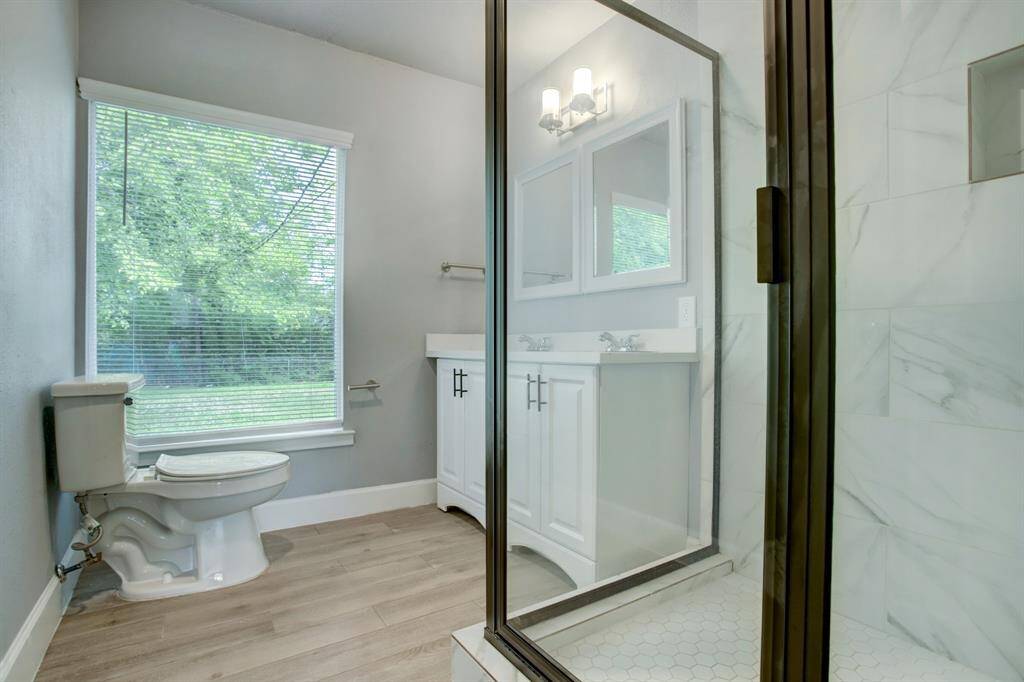 Walk in shower with double sink vanity.
