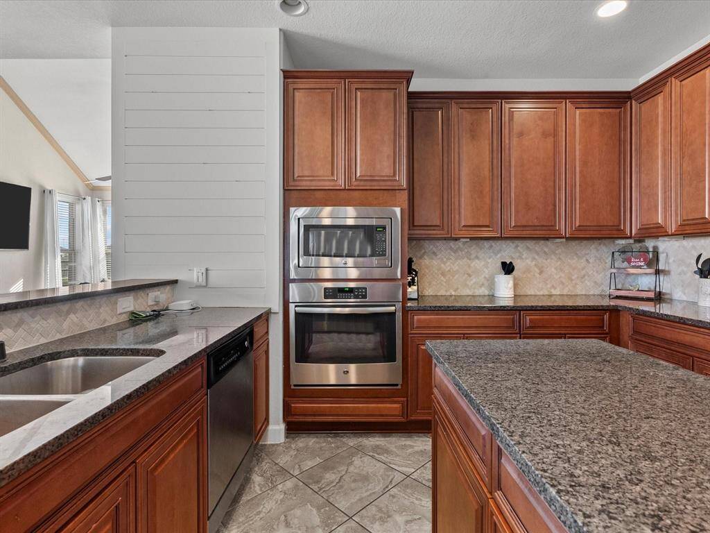 THE KITCHEN OFFERS GRANITE COUNTER-TOPS, S/S APPLIANCES AND KITCHEN ISLAND