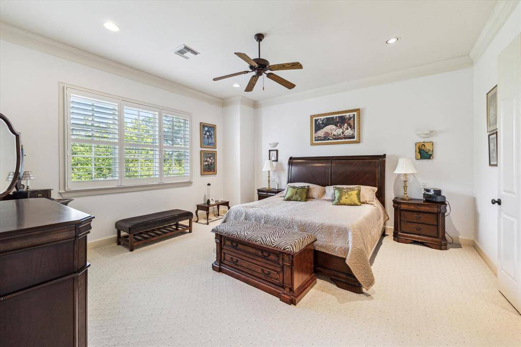Primary Bedroom Suite on Level three with carpet, high ceiling, crown molding, shutters, recessed lighting and ceiling fan.