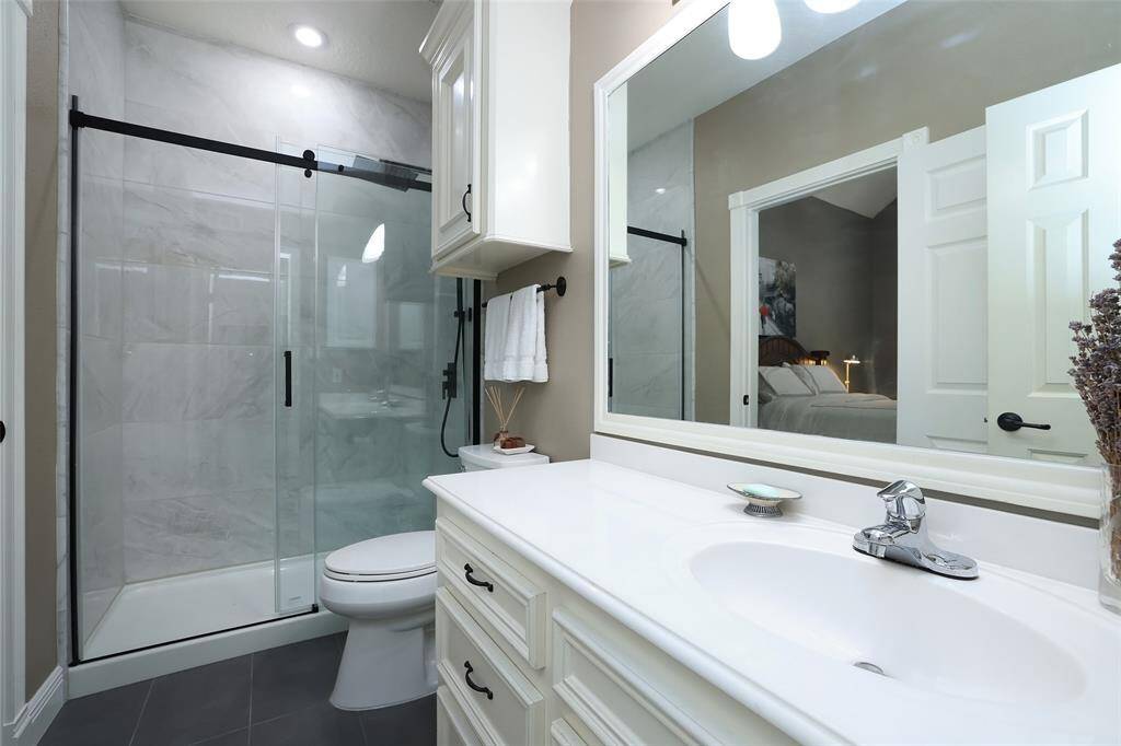 The full bath down in the ensuite bedroom has been remodeled. The previous tub and shower combo have been removed and a new shower added with room for seating if needed. Toilet has been replaced as well as  new flooring