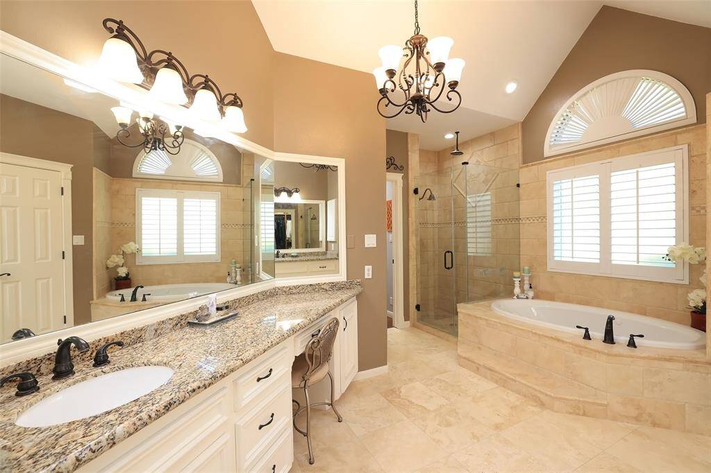 Another view of her side of the bathroom with sit down vanity area, large framed mirror and updated lighting.