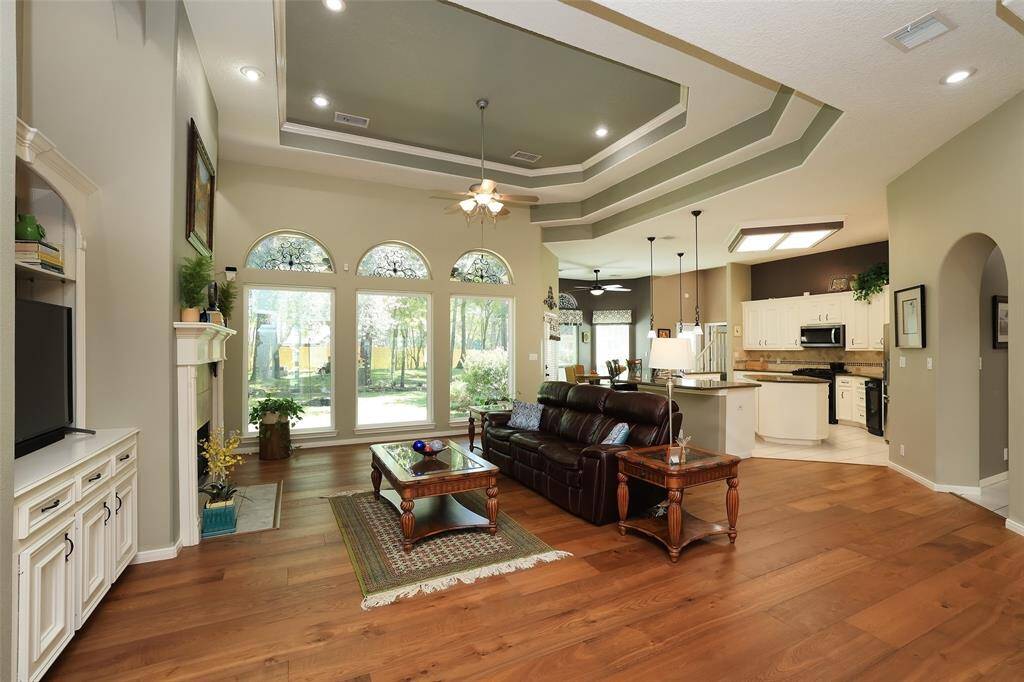 Lovely living area featuring style and functionality with tray ceiling, large windows to the private backyard all flowing seamlessly to the spacious island kitchen.