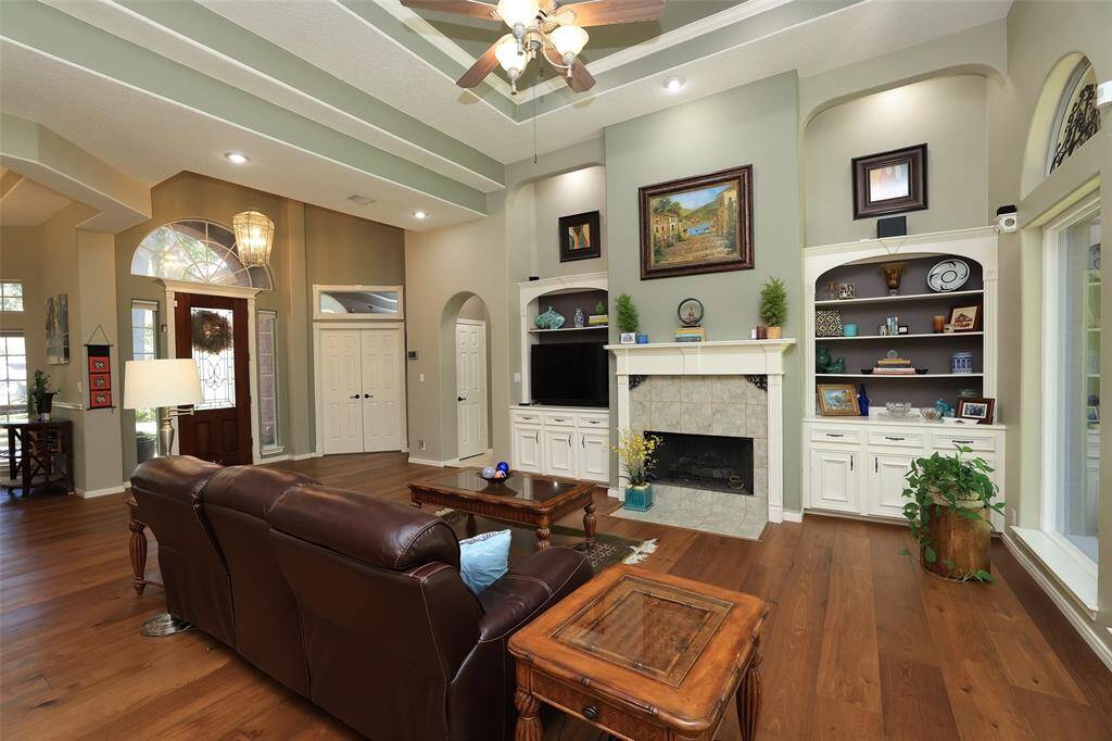 Another view of the family room with gas log fireplace and custom cabinets on either side.