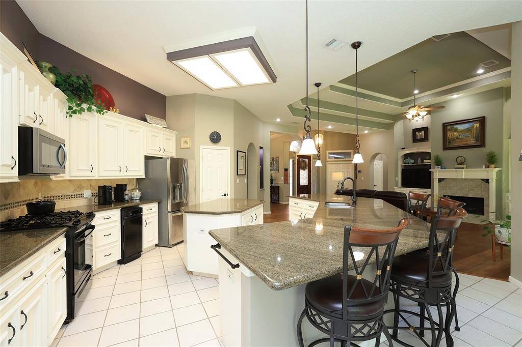 A chef's dream kitchen with plenty of bar seating, gas range and refrigerator to stay with the home.