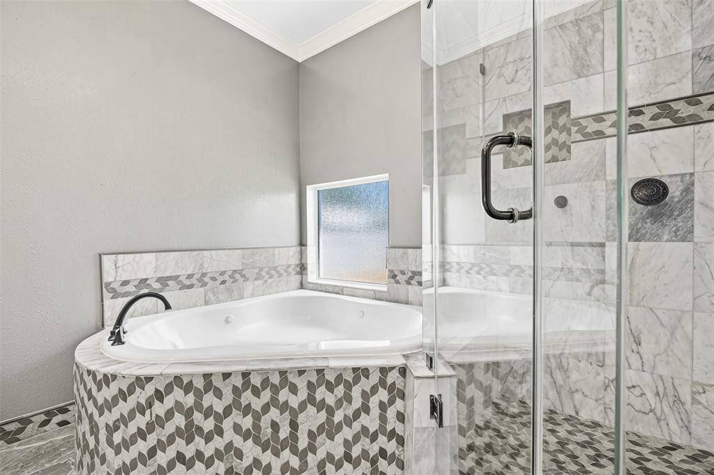 The owner’s suite offers elegance and serenity with crown molding, recessed lighting, and a chandelier fan, plus a spa-like bath with a jetted tub, separate shower, and his-and-hers custom vanities.