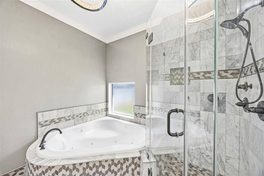 The owner’s suite offers elegance and serenity with crown molding, recessed lighting, and a chandelier fan, plus a spa-like bath with a jetted tub, separate shower, and his-and-hers custom vanities.