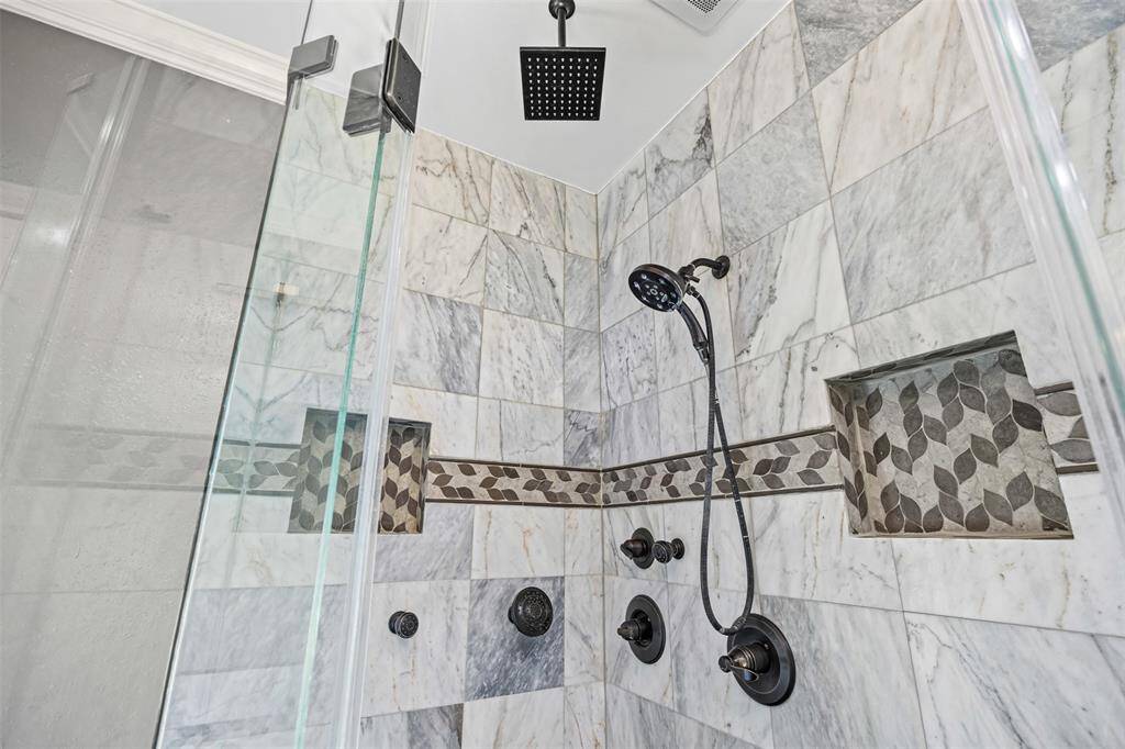The owner’s suite offers elegance and serenity with crown molding, recessed lighting, and a chandelier fan, plus a spa-like bath with a jetted tub, separate shower, and his-and-hers custom vanities.