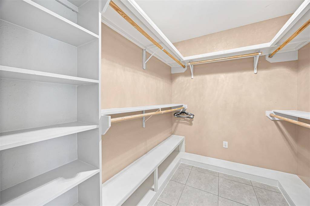 The owner’s suite offers elegance and serenity with crown molding, recessed lighting, and a chandelier fan, plus a spa-like bath with a jetted tub, separate shower, and his-and-hers custom vanities.
