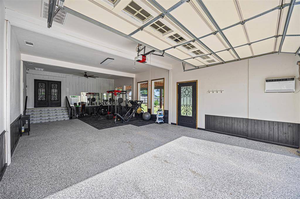 oversized garage with 12 ft ceilings, a 2.5-ton AC unit, commercial fan, and wall AC unit—ideal for workspace, storage, or your home gym.