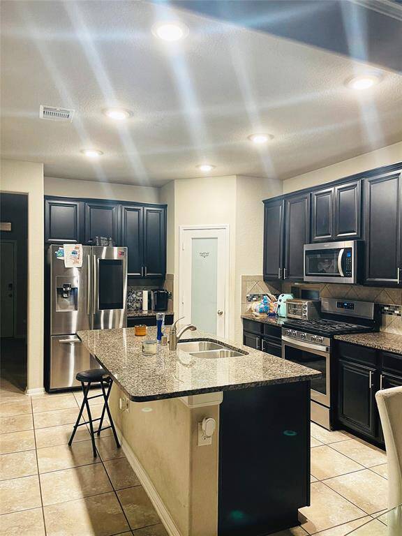 This is a modern two-story brick home with a two-car garage. It features a well-maintained front lawn, a small tree, and a welcoming entryway. The exterior combines brick and siding, providing a classic yet contemporary look.