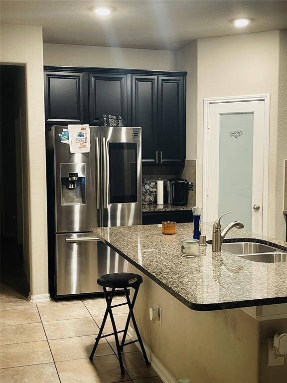 This is a modern two-story brick home with a two-car garage. It features a well-maintained front lawn, a small tree, and a welcoming entryway. The exterior combines brick and siding, providing a classic yet contemporary look.