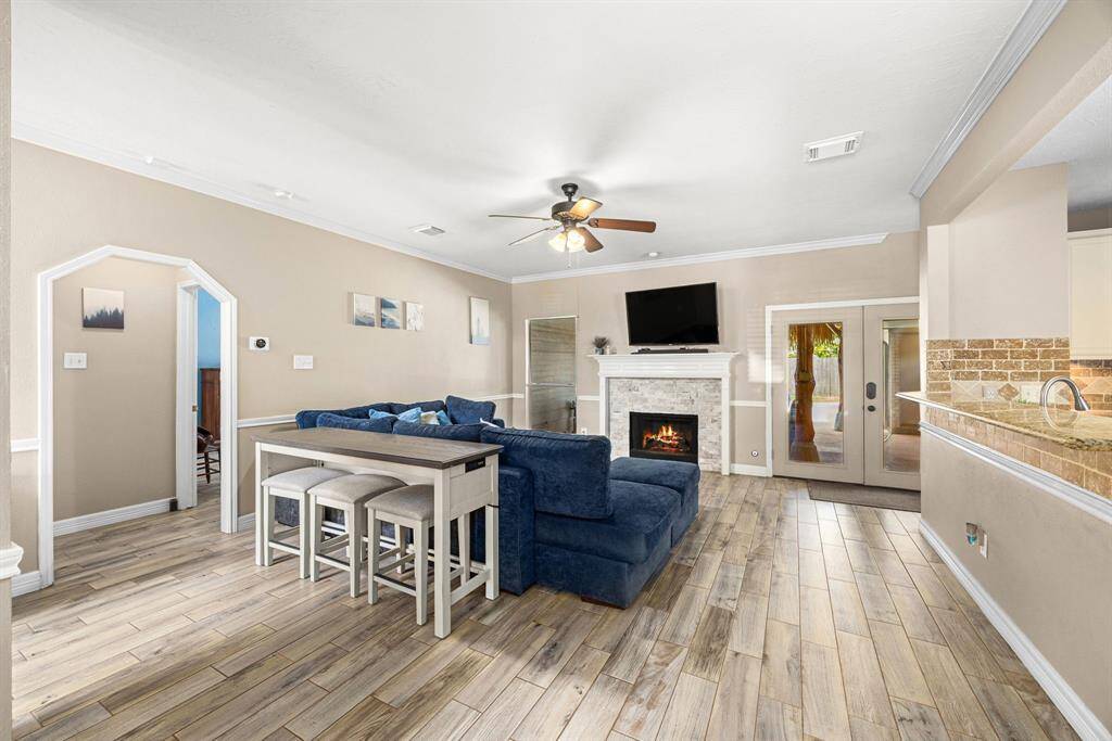 Spacious den with fireplace opens to kitchen bar.