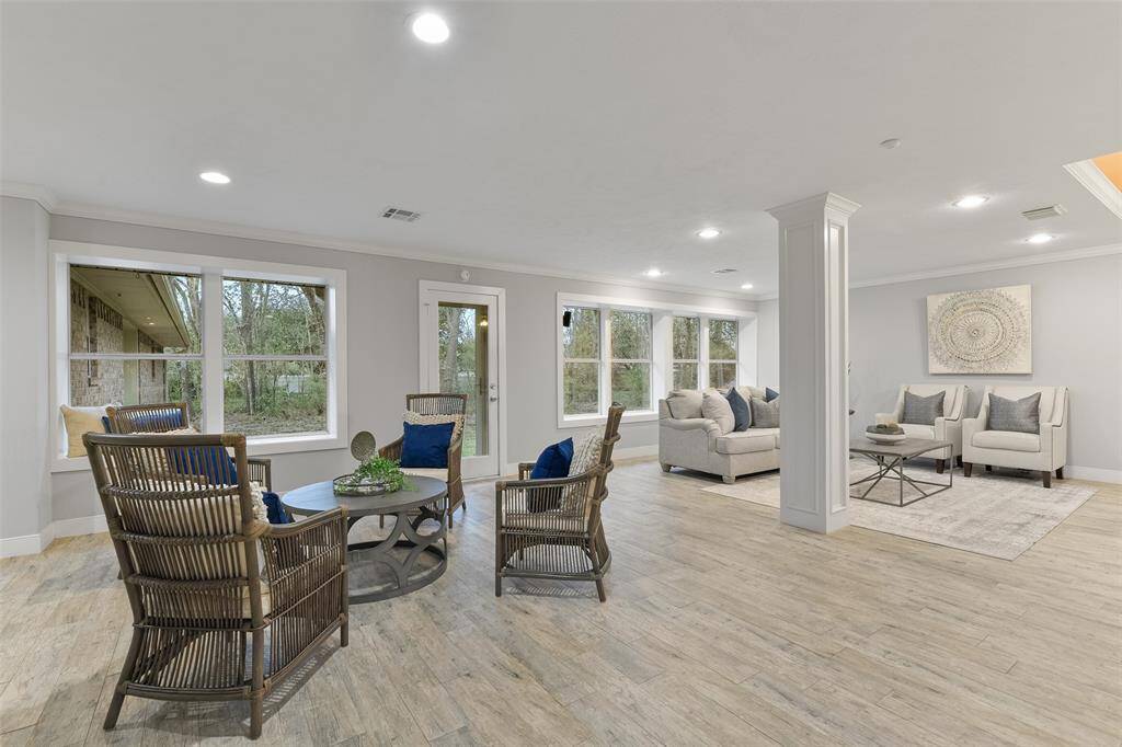 Along the far side of the kitchen and blending seamlessly into the family room, there is a generously proportioned gathering space with recessed lighting, wood-look tile flooring, crown molding, and an expansive cased window with a window seat.