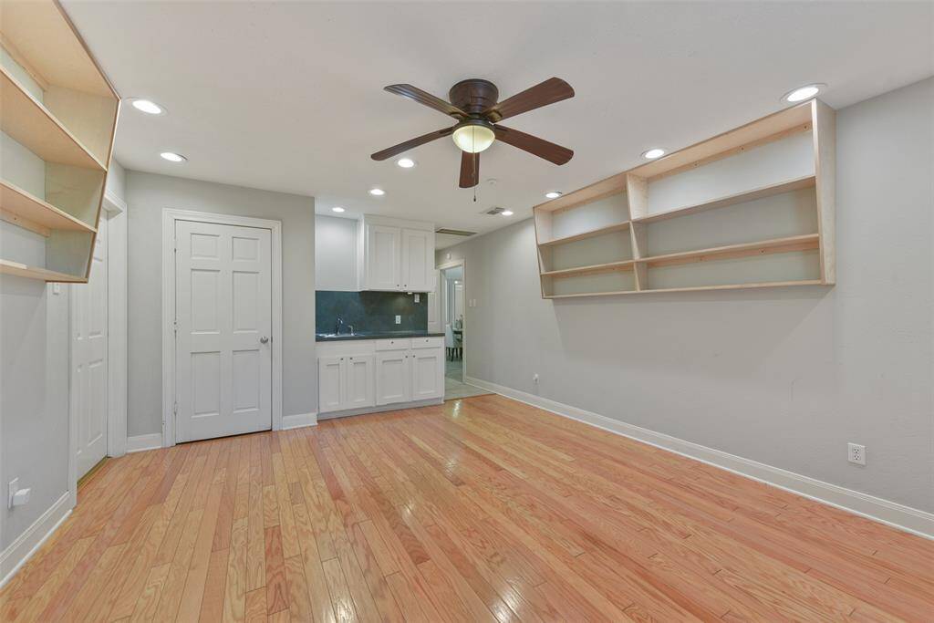 This flexible-use space is secluded off of the kitchen and it could serve as a bedroom, craft room, exercise room, or whatever you dream of. It offers interior, exterior, & garage access doors, wood floors, a wet bar with lockable cabinets, recessed lights, a ceiling fan, and an adjacent bath.