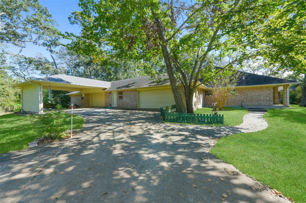 An automatically controlled gated and paved driveway makes its way to the left side of the home where you'll find a 2-car wide port cochere, a 2-car attached garage, and an impressive 34'x30' workshop space with front and back bay doors & plenty of cabinetry.