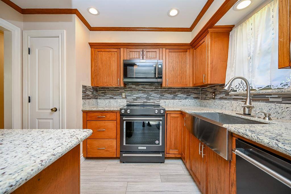 Granite countertops, custom-made cabinets, matching appliances, farmhouse sink and pantry make meal prep a pleasant experience!