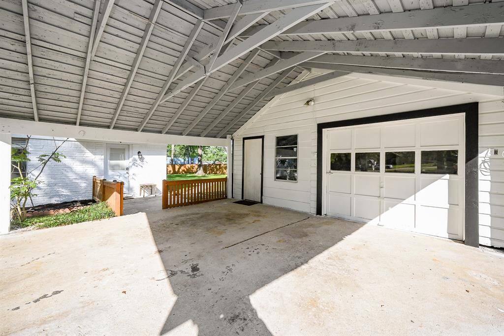 Detached garage, carport, storage room, and work room.  A concrete slab, to park a camper or boat, flanks the side of the garage.