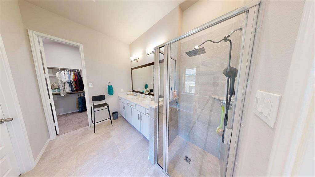 Separate shower with glass door on the right side of the primary bath