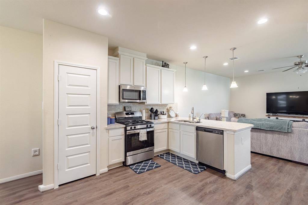 Experience the elegance of high ceilings and a bright, airy kitchen featuring stainless steel appliances and a spacious peninsula.