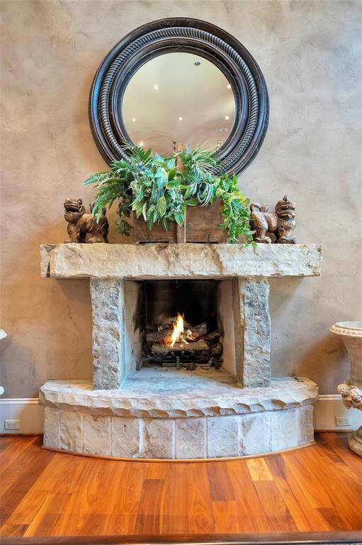 The family room is centered around this cozy wood-burning fireplace with gas connections composed of uncut individual stone boulders for the raised hearth, legs, and mantle.