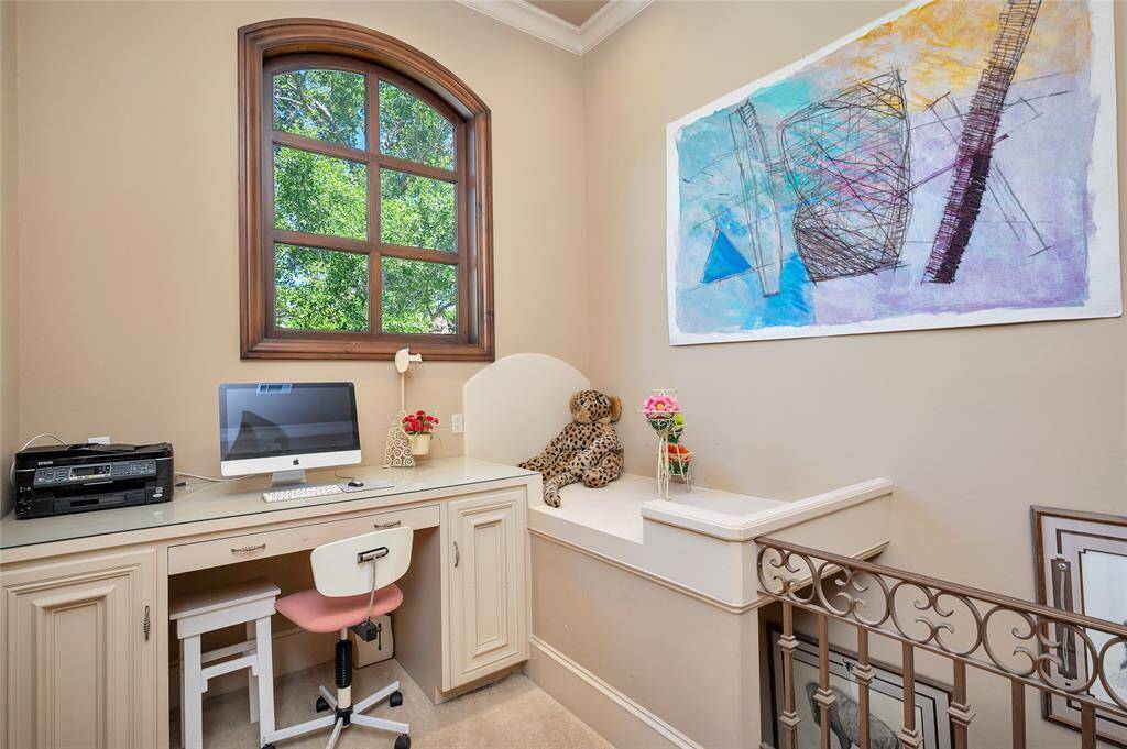 The second-floor office space with a built-in desk and adjacent built-in twin bed frame is accessible from the primary bedroom office staircase and upstairs blue secondary bedroom. Highlights include neutral carpet flooring, an arched window, crown molding, and recessed lighting.