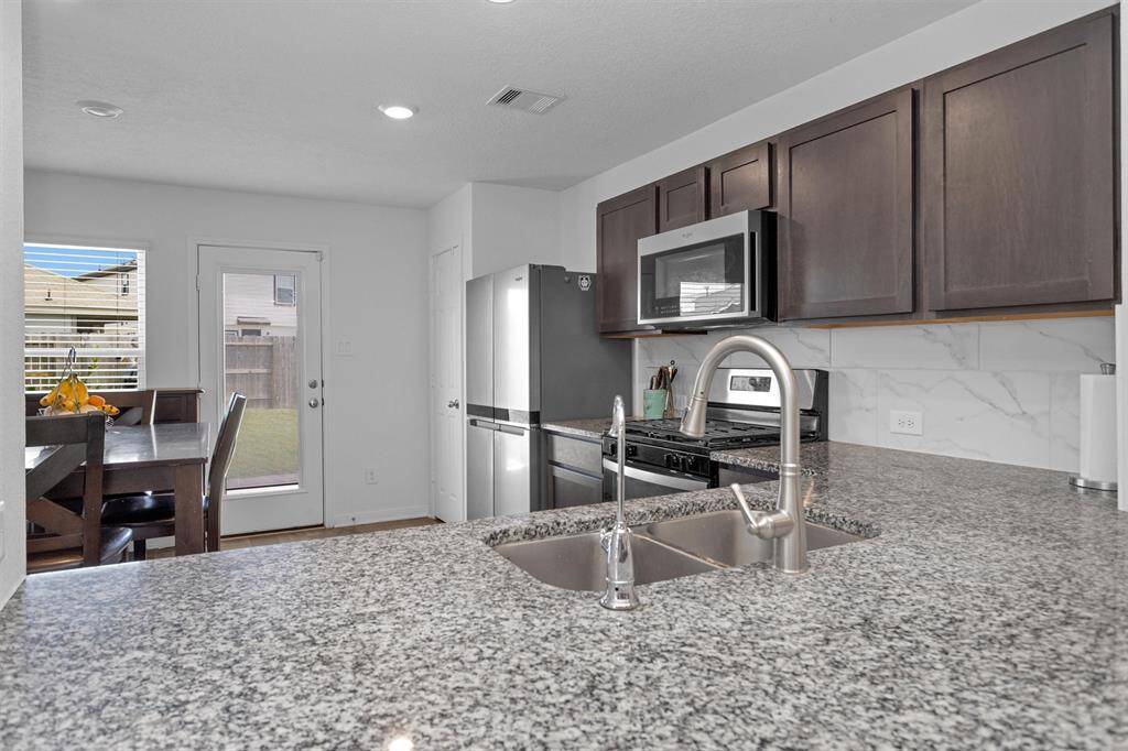 The kitchen features granite counter tops, tile backsplash and beautiful cabinets!