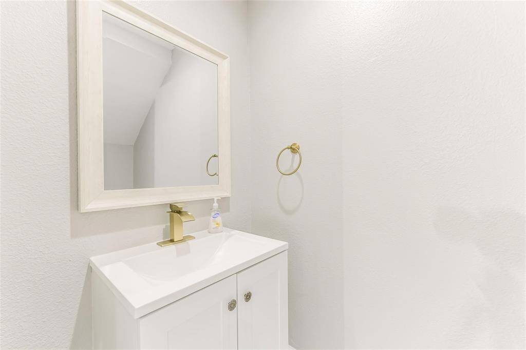 Downstairs half bath with a touch of classic gold finishes throughout