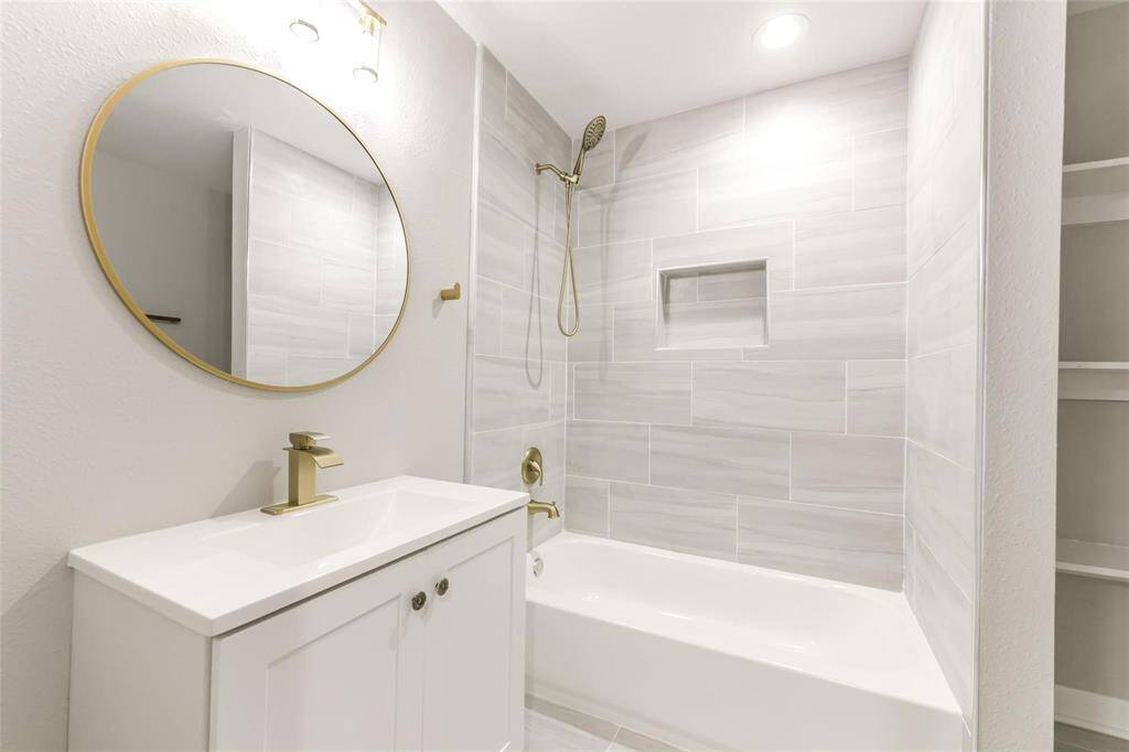 Shared upstairs bathroom with modern gold touches and shower/bath combo