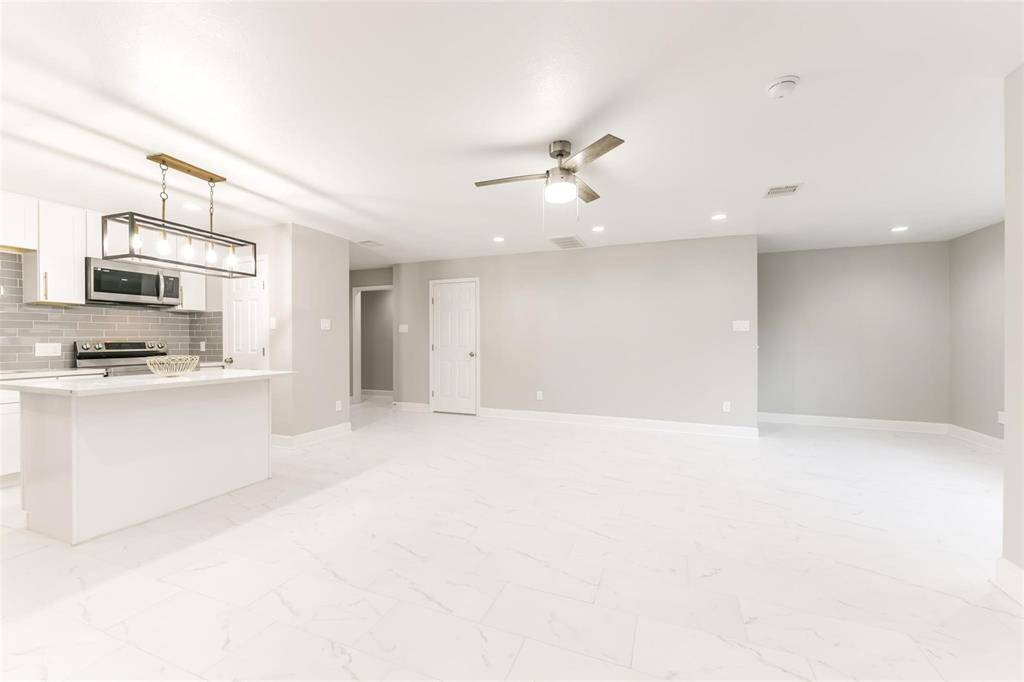 First floor has a wide floor plan, offering ample space for entertainment, dining, and a tucked away staircase leading to the second floor and entrance to the garage