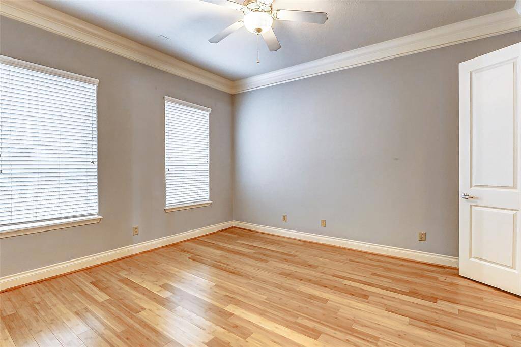 Retreat to your elegant primarysuite that features double crownmolding, luxe paint, wood floorsand two bright windows thatallow natural light to gently filterin through the privacy shades. You also have access to your walk-in closet that has built-in storage and hanging space for a large wardrobe.