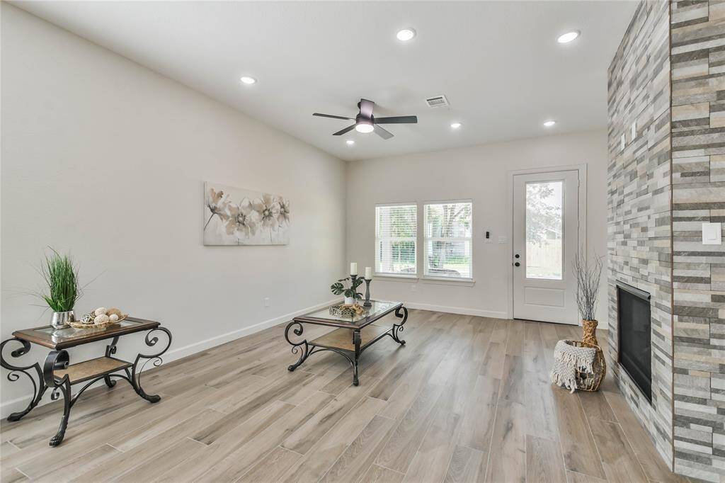 Spacious family room with floor to ceiling stone fireplace as the focal point.