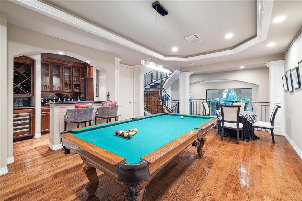 A billiard room with full wet bar overlooking living room providing an ideal entertaining space.