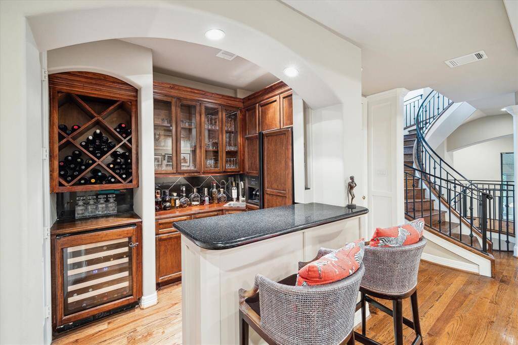 A full wet bar with custom paneled refrigerator, beverage refrigerator and sink.