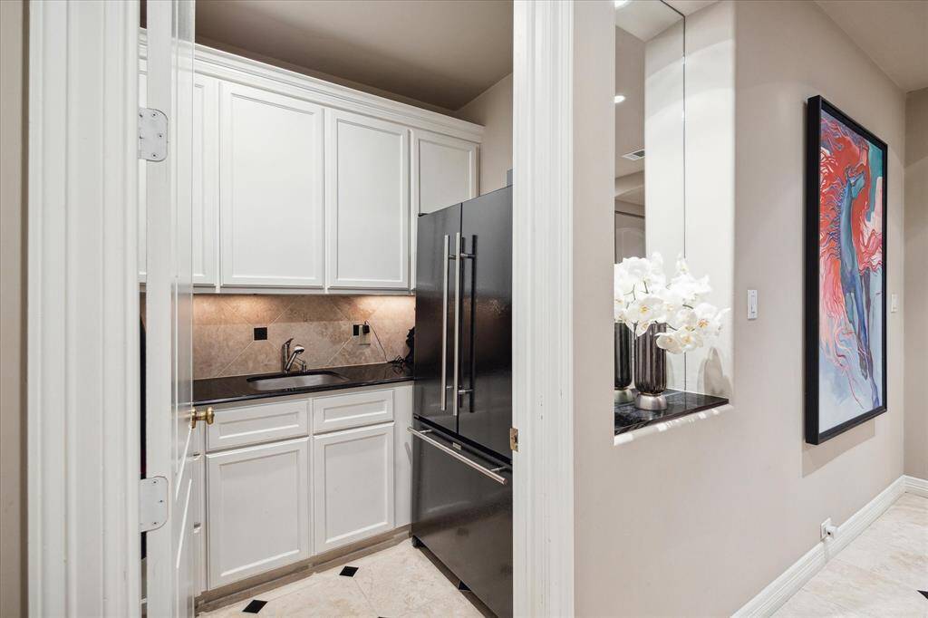 A full utilitarian mudroom found off the entry with sink and refrigerator. An area that is sure to be appreciated.