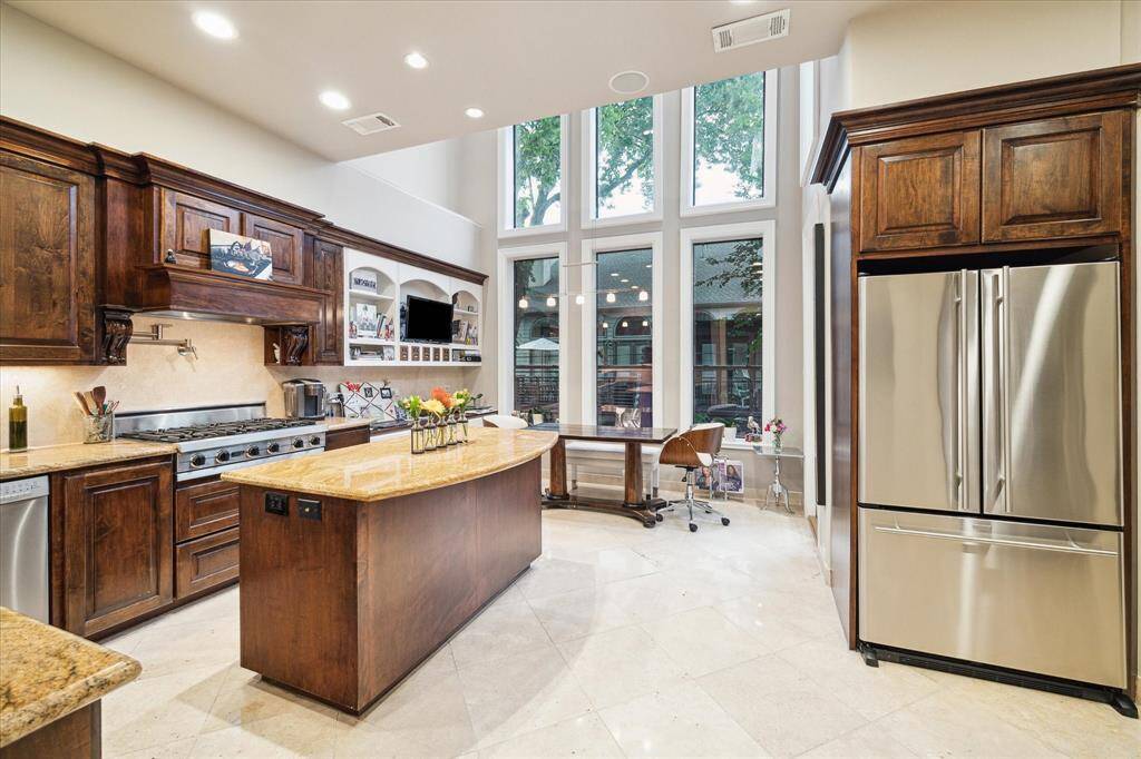 An exquisite chefs kitchen with pot filler, dual dishwashers, breakfast room, outdoor balcony overlooking pond and more.