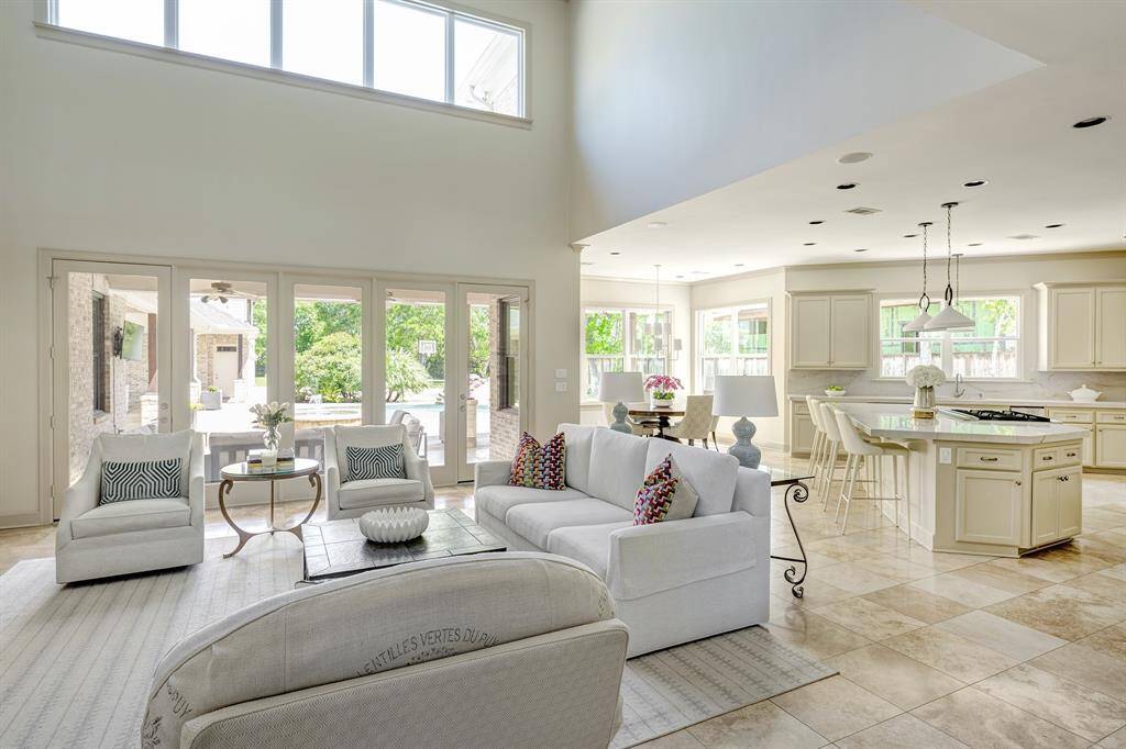 Light-filled great room with soaring ceiling and kitchen in the background